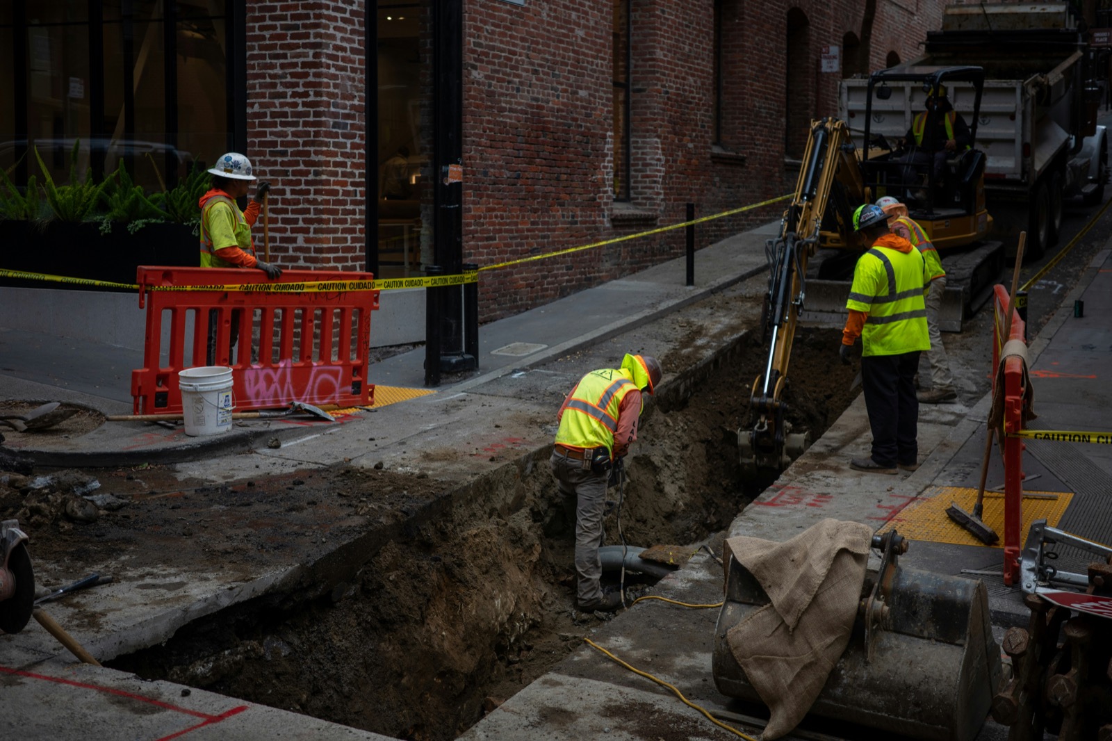 Public utility workers in hi-vis on a street excavation