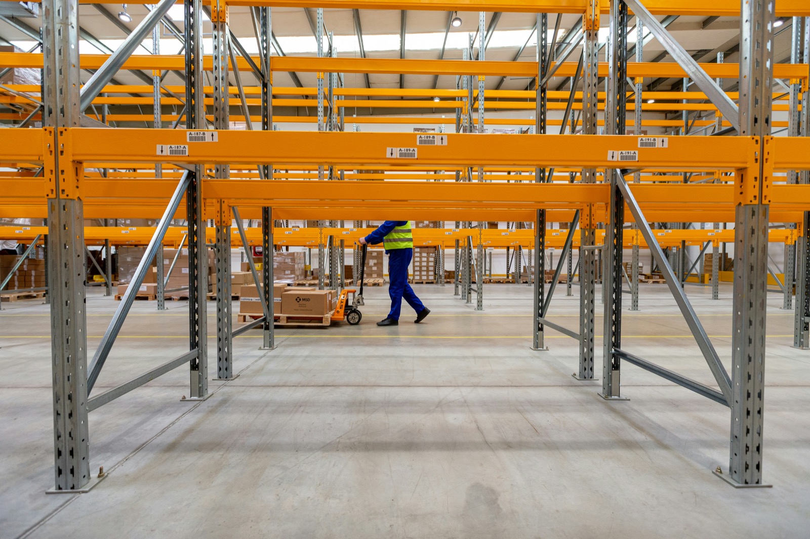 Warehouse worker handling parcels in branded uniform